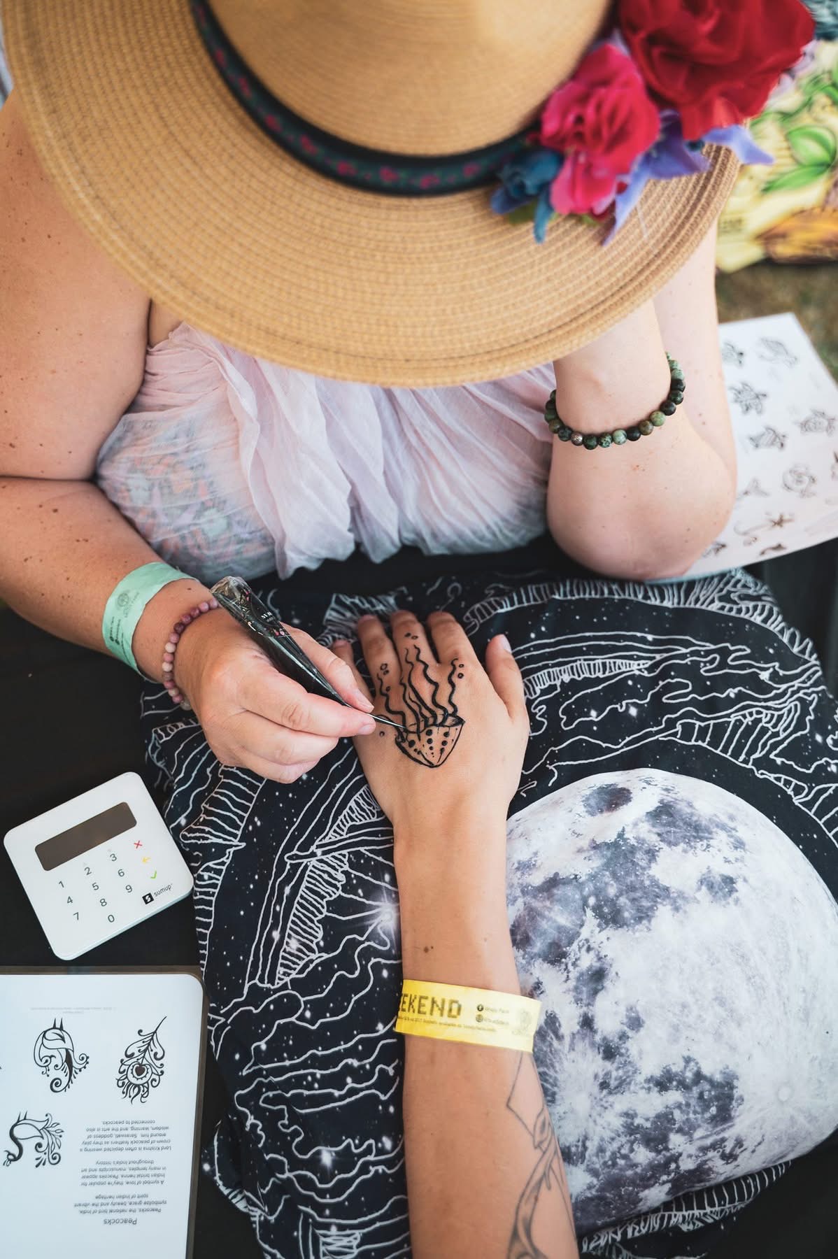 Lena creating a freehand henna design